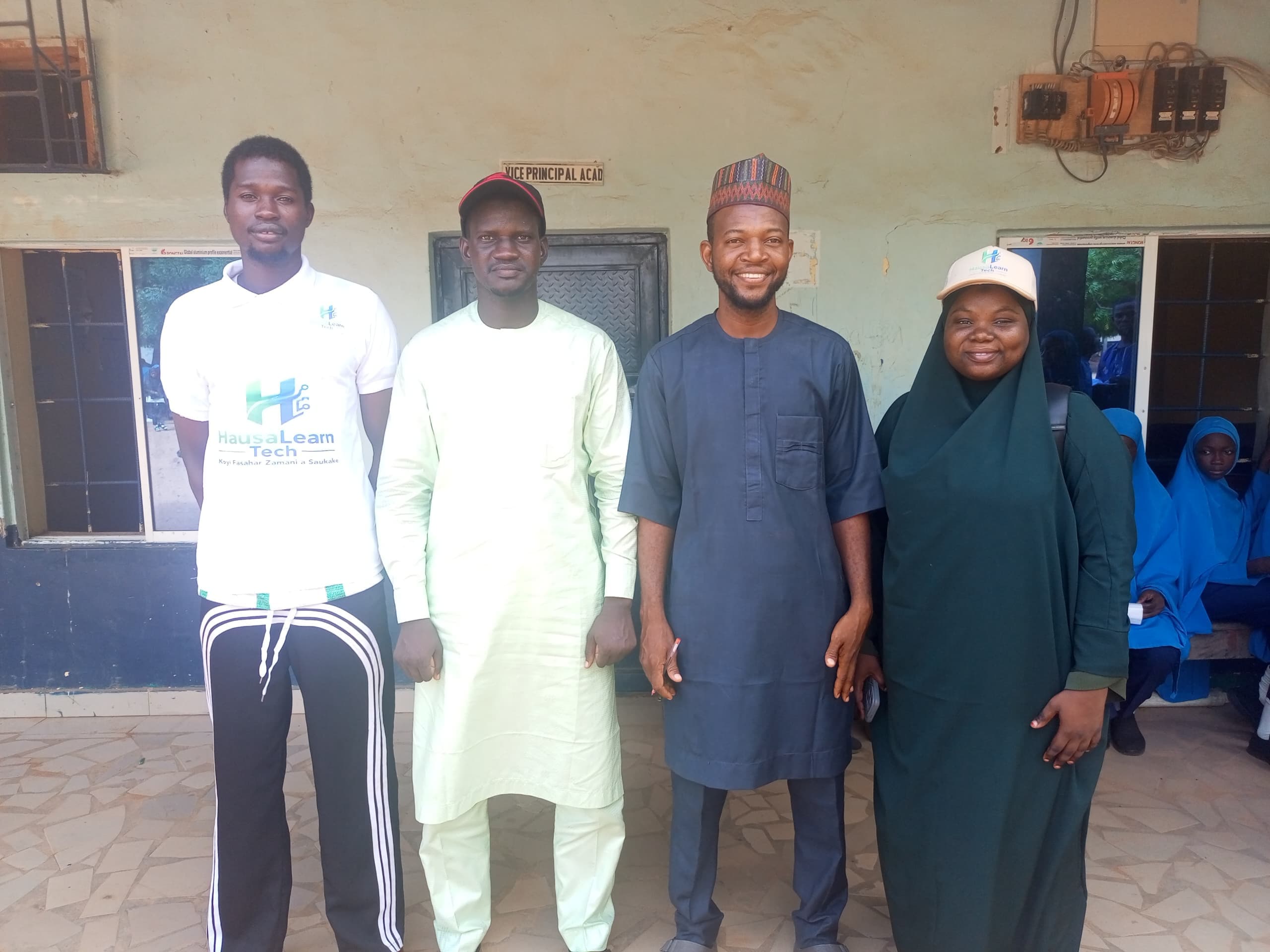 HausaLearn Tech representatives standing with educators during a campus visit